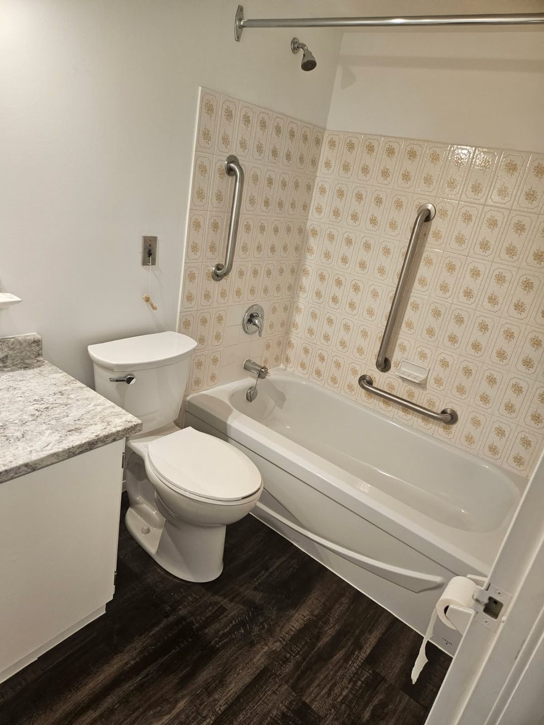 A finished accessible bathroom with grab bars and a toilet in Belleville, Ontario