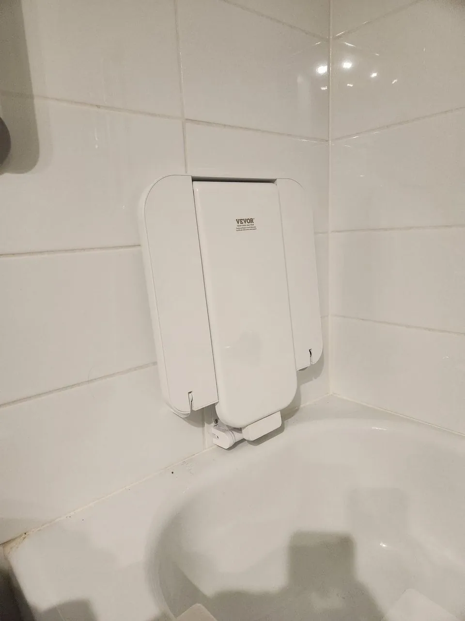 A fold-down shower seat and grab bars fitted for a safe, supported wash